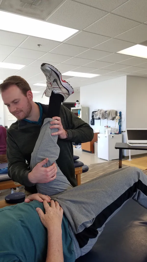 A therapist helping a patient stretch a hamstring